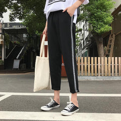 Pantalones deportivos de moda con líneas brillantes en los laterales, de gran tamaño