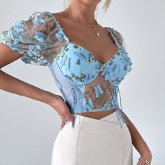 Top corto de malla con mangas abullonadas y bordado floral en azul pastel