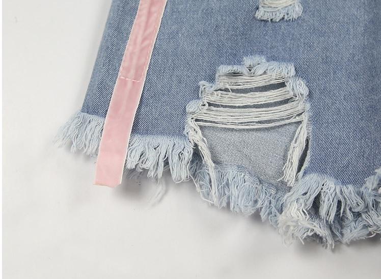 Shorts vaqueros azul claro con agujeros y líneas rosas laterales 